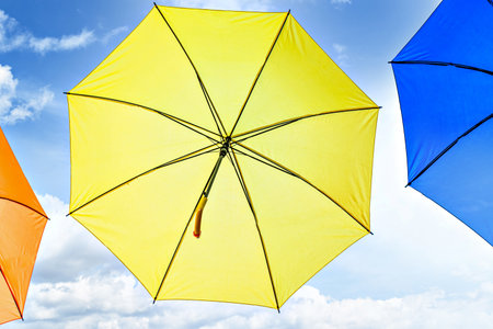 Background of many hanging colorful umbrellas decorating the street of a townの写真素材