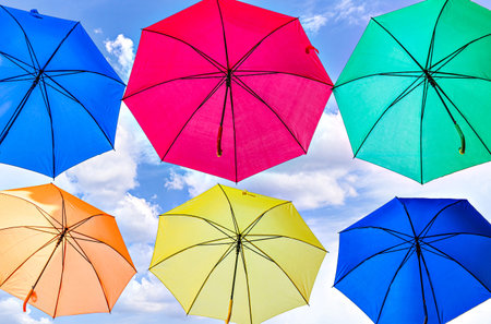 Background of many hanging colorful umbrellas decorating the street of a townの写真素材