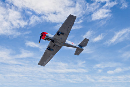 View of an aerobatic plane (aerodyne), in flight under a blue sky with white clouds. flight exhibitionsの写真素材