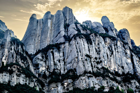 Views of the Montserrat massif, a mountain in the province of Barcelona, ââCatalonia with an orange sunset skyの写真素材