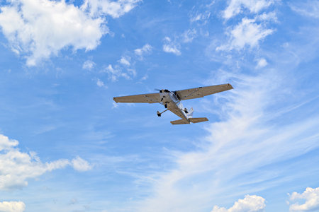 Single engine ultralight plane flying in the blue sky with white cloudsの写真素材