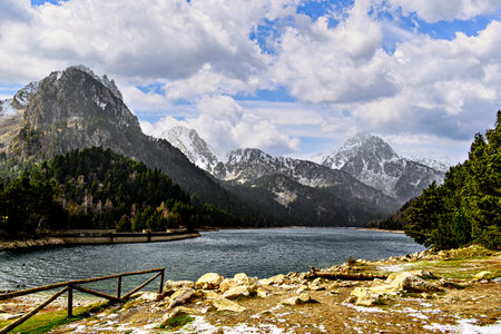 Image of Sant Maurici Lake with snow-capped mountains, in the Aigües Tortes National Park, in the Lleida Pyrenees, Catalonia, Spainの写真素材
