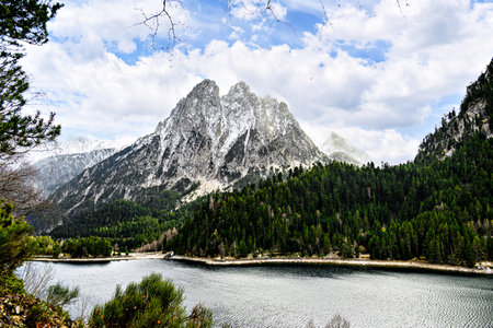 Image of Sant Maurici Lake with snow-capped mountains, in the Aigües Tortes National Park, in the Lleida Pyrenees, Catalonia, Spainの写真素材