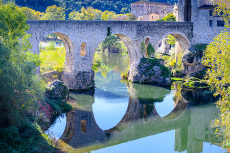 Famous medieval bridge over the river Fluvia in the medieval village of Besalú, Girona, Catalonia, Spainの写真素材