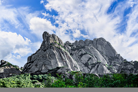 Views of the Montserrat massif, mountain in the province of Barcelona, Catalonia on a day with blue sky and white cloudsの写真素材