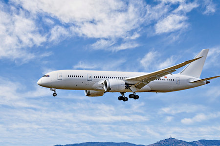 Passenger plane landing at the airport, under a blue sky with white cloudsの写真素材