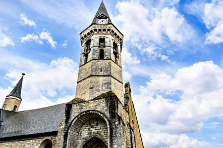 Church of San Miguel in Romanesque-Gothic style, in Viella, Valle de Aran, Catalonia, Spain, under a blue sky with white cloudsの写真素材