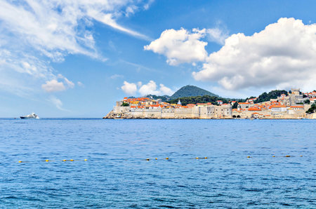 View of the old town of Dubrovnik behind its walls under a blue sky with white clouds, Croatiaの写真素材
