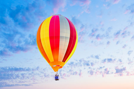 Colorful hot air balloon flying over blue sky with white cloudsの写真素材