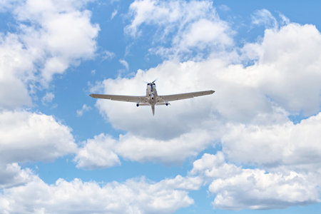 Passenger plane flying in the blue sky with white clouds in summer day