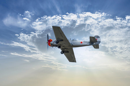 View of an aerobatic plane (aerodyne), in flight under a blue sky with white clouds. flight...
