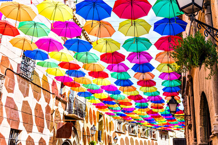 Background of many hanging colorful umbrellas decorating the street of a townの写真素材