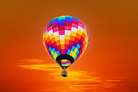 Colorful hot air balloon flying in the blue sky at sunset.の写真素材