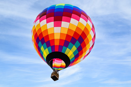 Colorful hot air balloon flying in the blue sky with white cloudsの写真素材