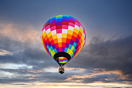 Colorful hot air balloon flying in the blue sky at sunset.の写真素材