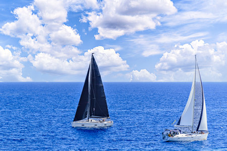 Boat, sailboat sailing under a blue sky with white cloudsの写真素材