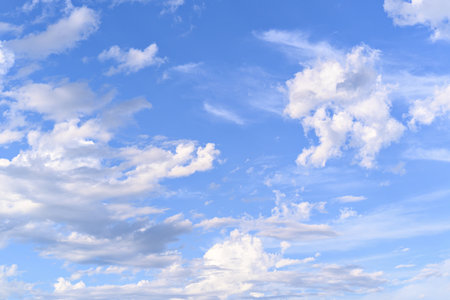 Blue sky background with tiny clouds. White fluffy clouds in the blue sky.の写真素材