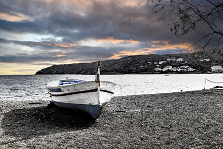 Typical fishing boat on the beach at sunset in the picturesque coastal town of CadaquÃ©s, Costa Brava, Girona. Black and white effectの写真素材