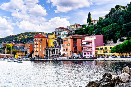 Image of the picturesque village and beach of Villefranche-sur-Mer, France with tourists in August, with its colorful houses.の写真素材