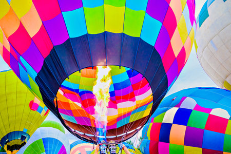 Colorful hot air balloon flying over blue sky with white cloudsの写真素材