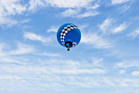 Colorful hot air balloon flying over blue sky with white cloudsの写真素材