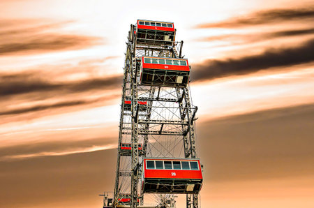 Ferris wheel with red cabins at sunset in Prater amusement park in Vienna Austria.の写真素材