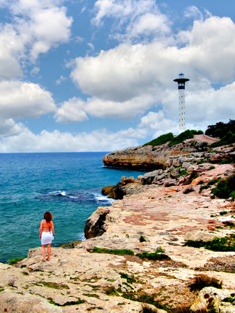 Woman walking on the path that leads to Torredembarra Lighthouseの写真素材