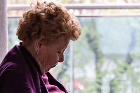 Elderly woman sitting by the windowの写真素材