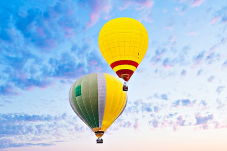 Colorful hot air balloon flying under orange sunset skyの写真素材