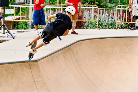 Young man practicing Scootering (Freestyle Scootering) at the SkatePark in Igualada, Spain
