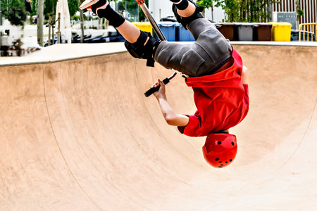 Young man practicing Scootering (Freestyle Scootering) at the SkatePark in Igualada, Barcelona,...