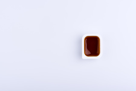 One fast food dip sauces in plastic containers containing red sauce in right side of image, isolated on white backgroundの写真素材