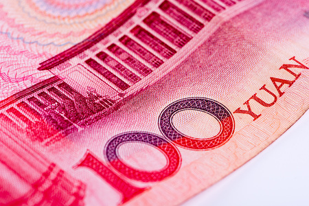 Closeup of Chinese 100 RMB yuan note, focusing on text 100 YUAN, on white background
