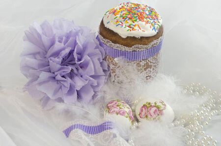Easter composition of Easter cake, down, bow and painted eggs