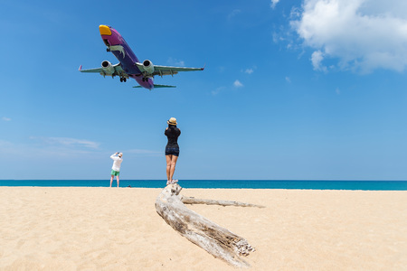 Portrait beautiful woman on the beach, Landing aircraft above the beach at Phuket Airport. Mai Khao beach, one of the most popular beaches among tourists in Phuket.のeditorial素材