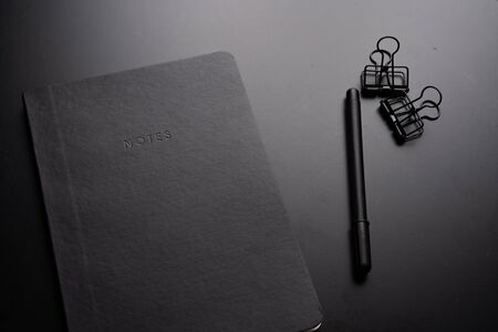 Black style set: notepad, pen and paper clips on Black background