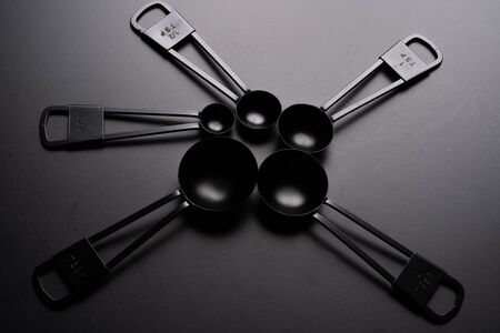 A set of black measuring spoon on black background.の写真素材