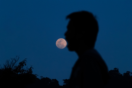 Playing silhouette shadow:The moon was eaten by the hungry man.の写真素材