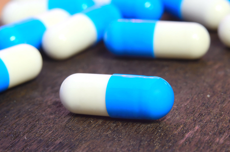close up medicine capsule pill on wood background