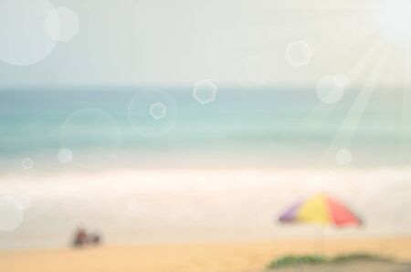Blur tropical beach with sun light and blue sky abstract background.Travel concept.の写真素材