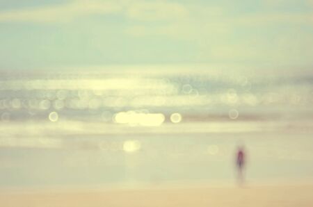 Blur man on beach with bokeh wave abstract background.Vintage color style.の写真素材
