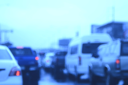 Blur traffic road with bokeh light in rainy day abstract background.