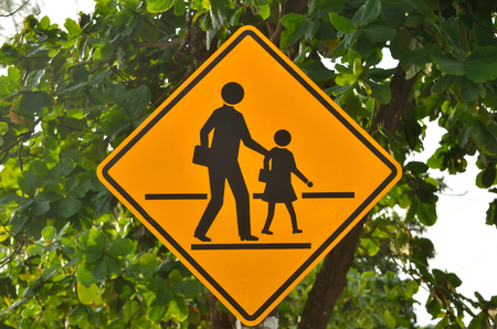 School sign.Traffic symbol warning be careful student cross road.の写真素材
