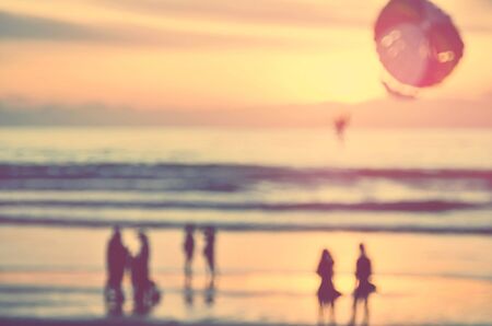 Blur people relax on tropical sunset beach abstract background.Travel concept.Retro color style.