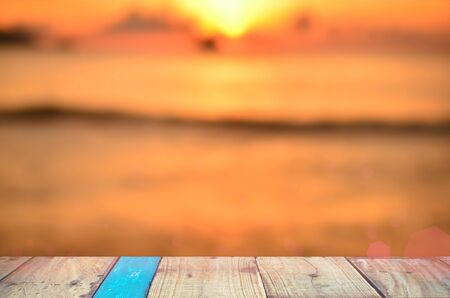 Blur tropical sunset beach with old empty wood table background. Product presentation in nature.の写真素材