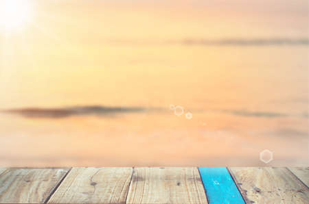 Blur tropical sunset beach with old empty wood table background.Product presentation in nature.