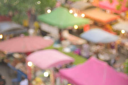Blur people shopping in local street market with colorful bokeh and sun light abstract background. Travel and business concept.の写真素材