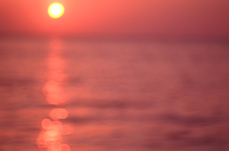 Blur tropical sunset beach with bokeh sun light wave abstract background. Travel concept. Retro color style.の写真素材