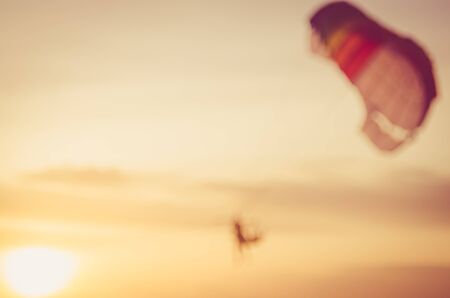 Blur people playing parachute boat on tropical beach abstract background. Travel background concept. Retro color style.の写真素材