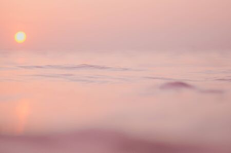 Blur tropical sunset beach with bokeh sun light wave abstract background. Travel concept. Retro color style.の写真素材